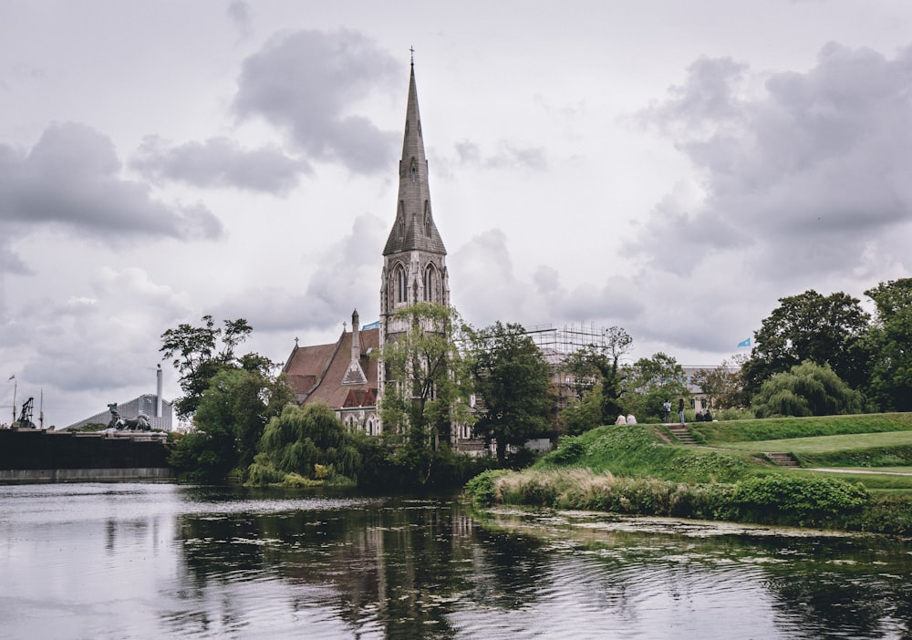 brown and gray concrete building near body of water under cloudy sky during daytime