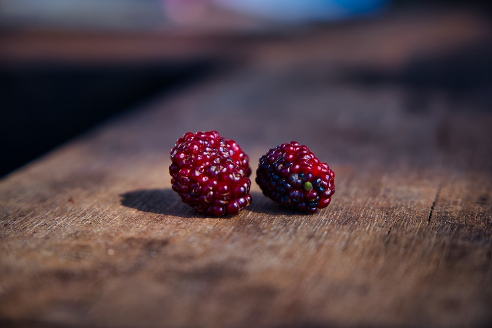 red raspberry on brown wooden table