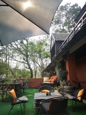 An inviting outdoor seating area on a black and white composite terrace with orange cushions.