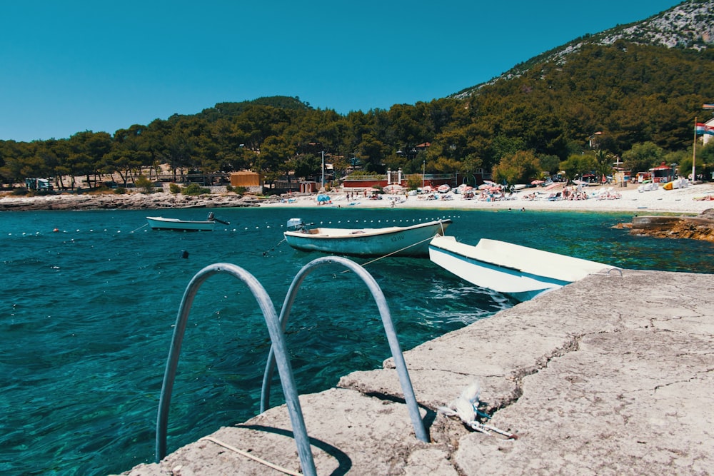 white boat on sea shore during daytime