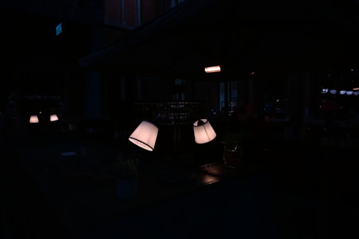 A dimly lit room with velvet curtains and a softly glowing vintage lamp casting warm shadows.