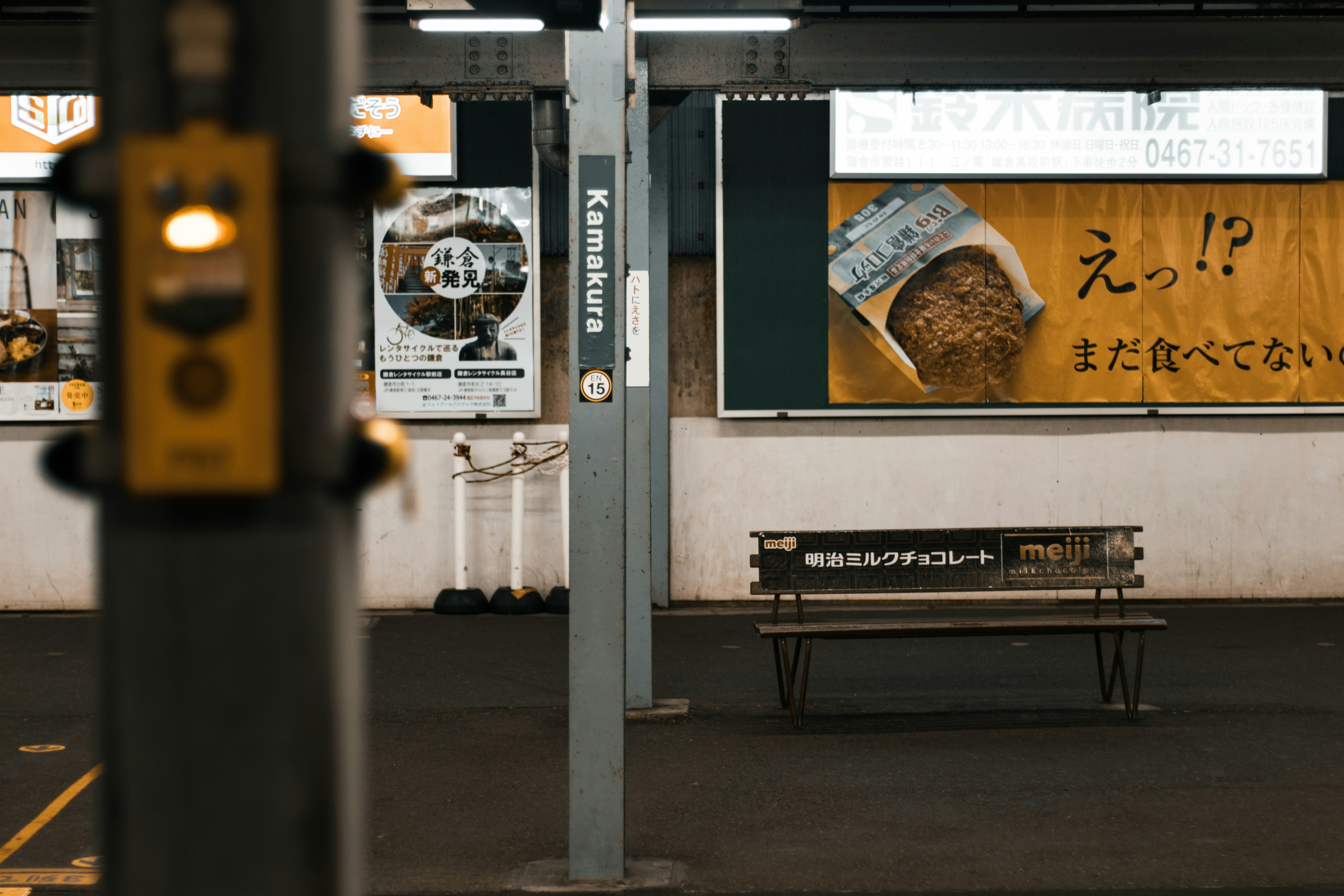 Un banco sentado en una estación de tren al lado de un edificio