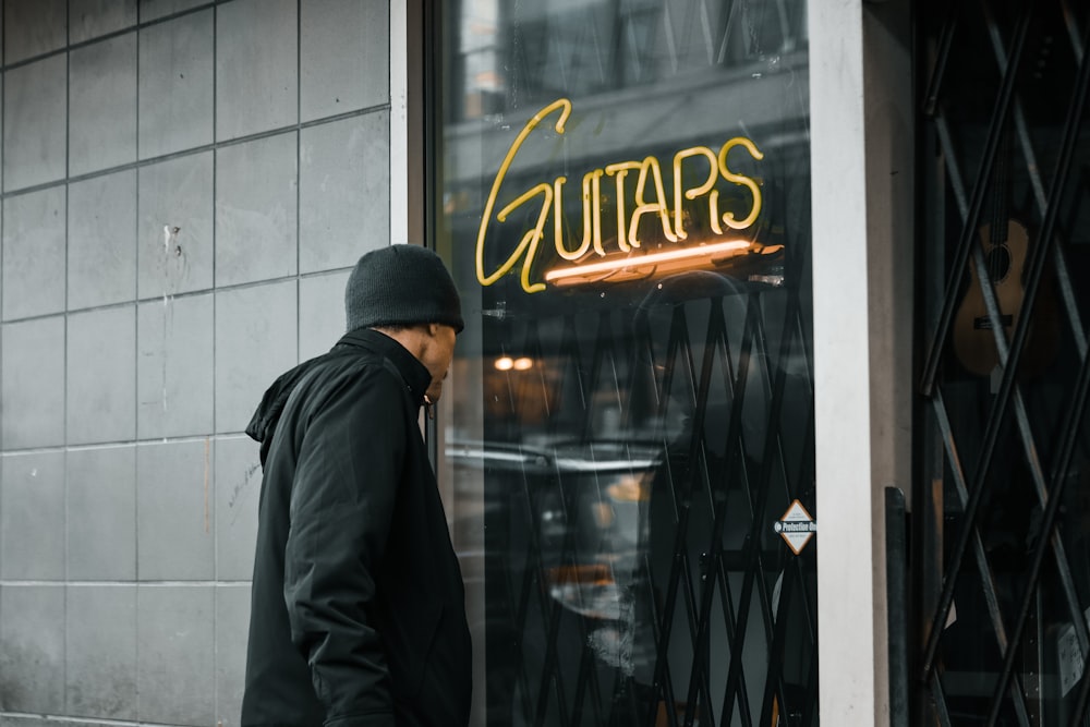 a man walking past a guitar shop