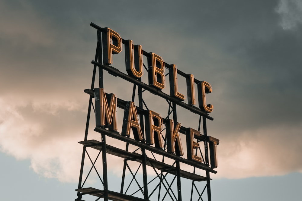 a public market sign on a cloudy day