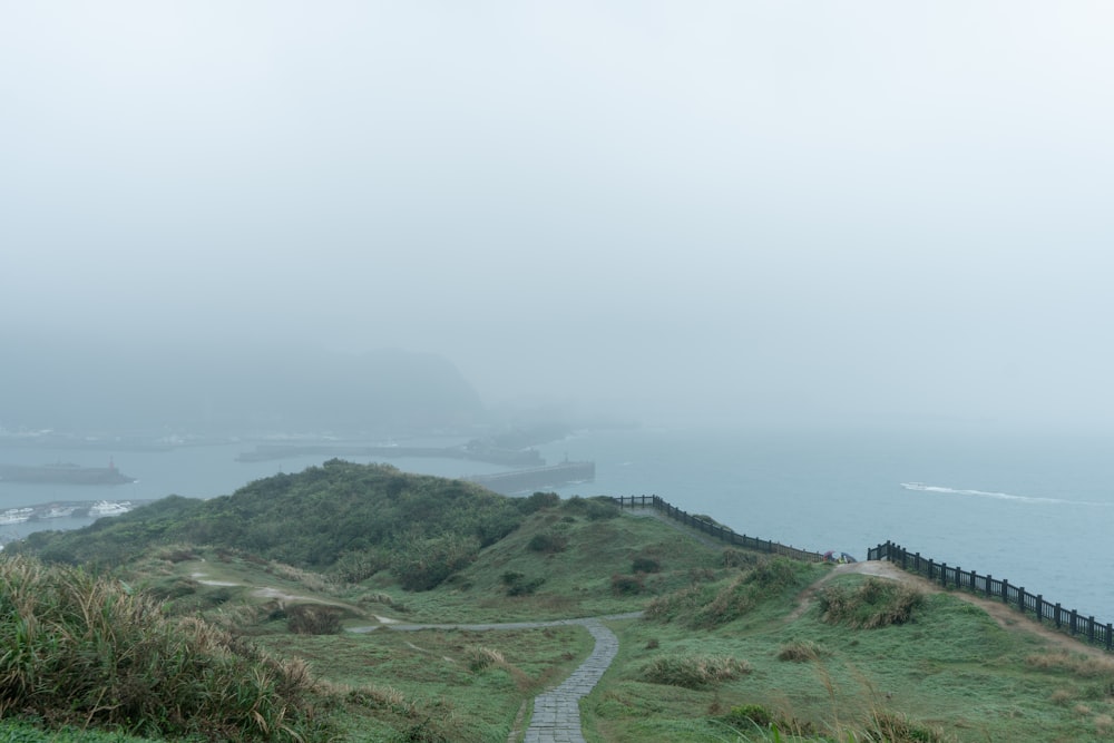 a foggy day at the top of a grassy hill