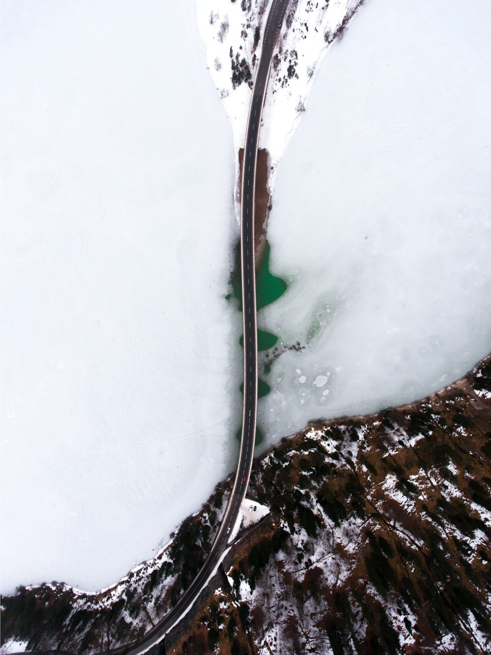 Une route sinueuse au milieu d’une montagne enneigée