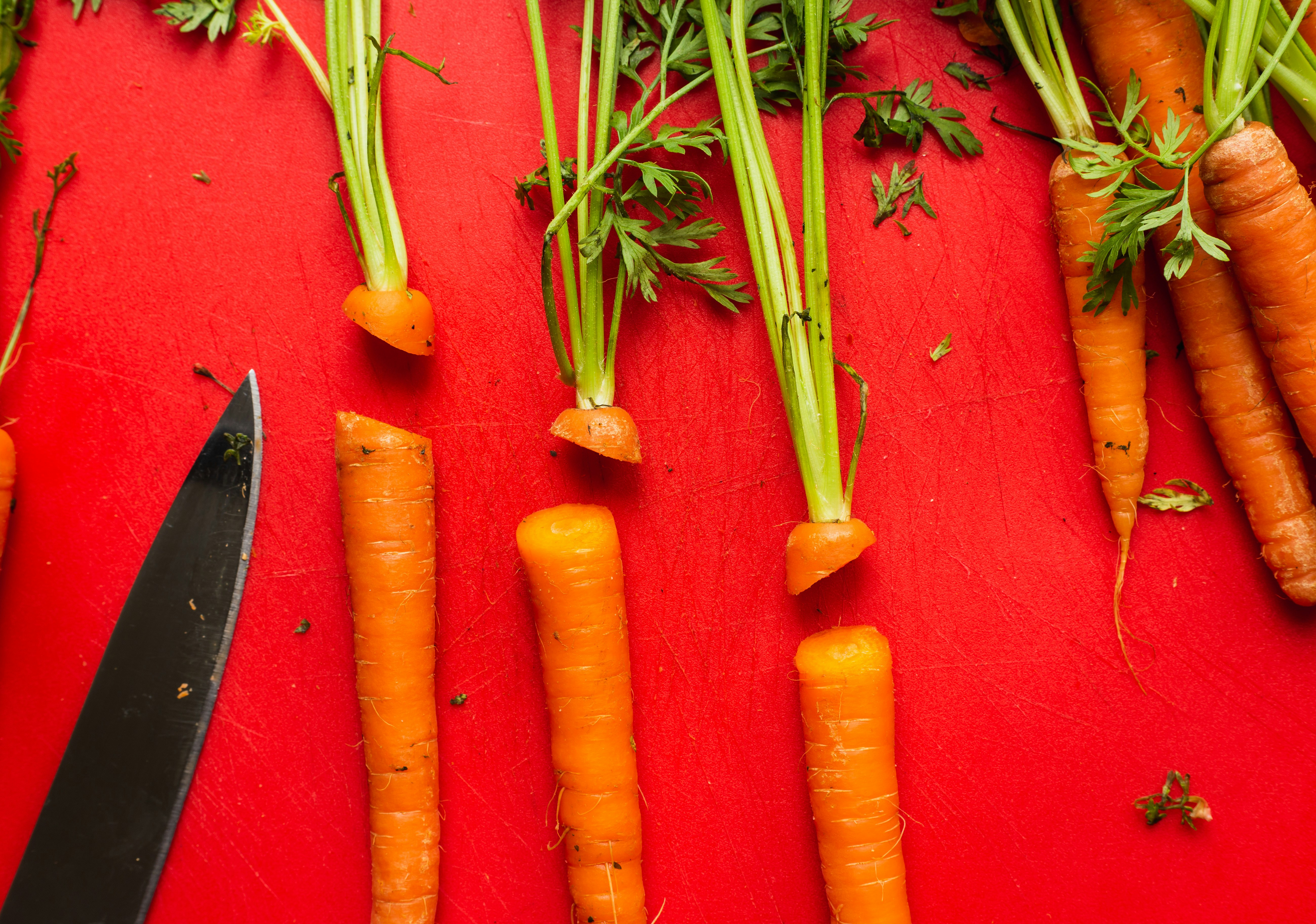 a bunch of carrots and a knife on a table