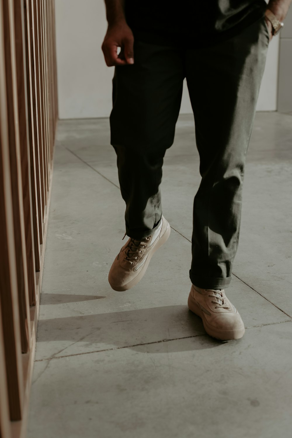 a man standing next to a wooden wall