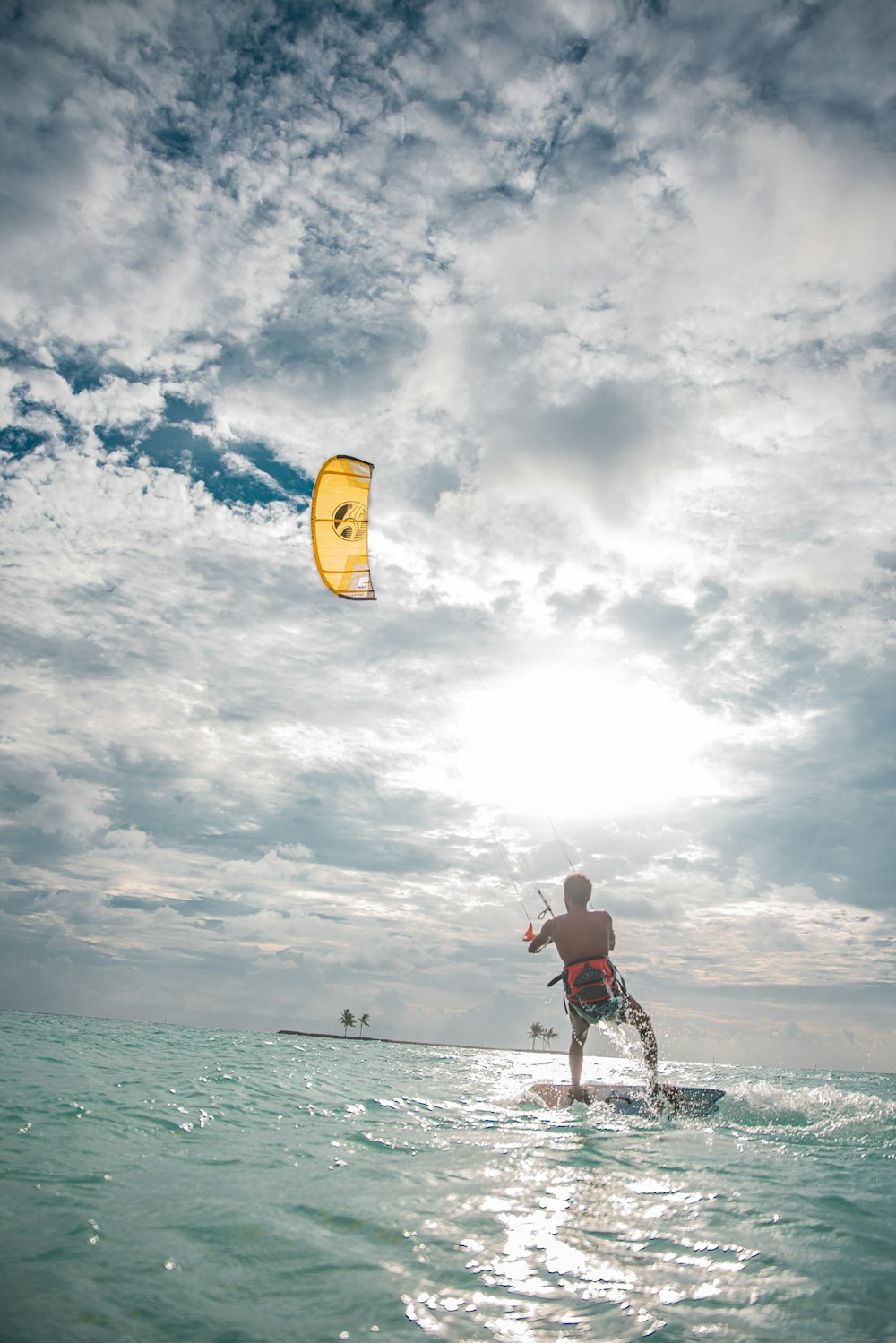 um homem montando um kiteboard em cima de um corpo de água