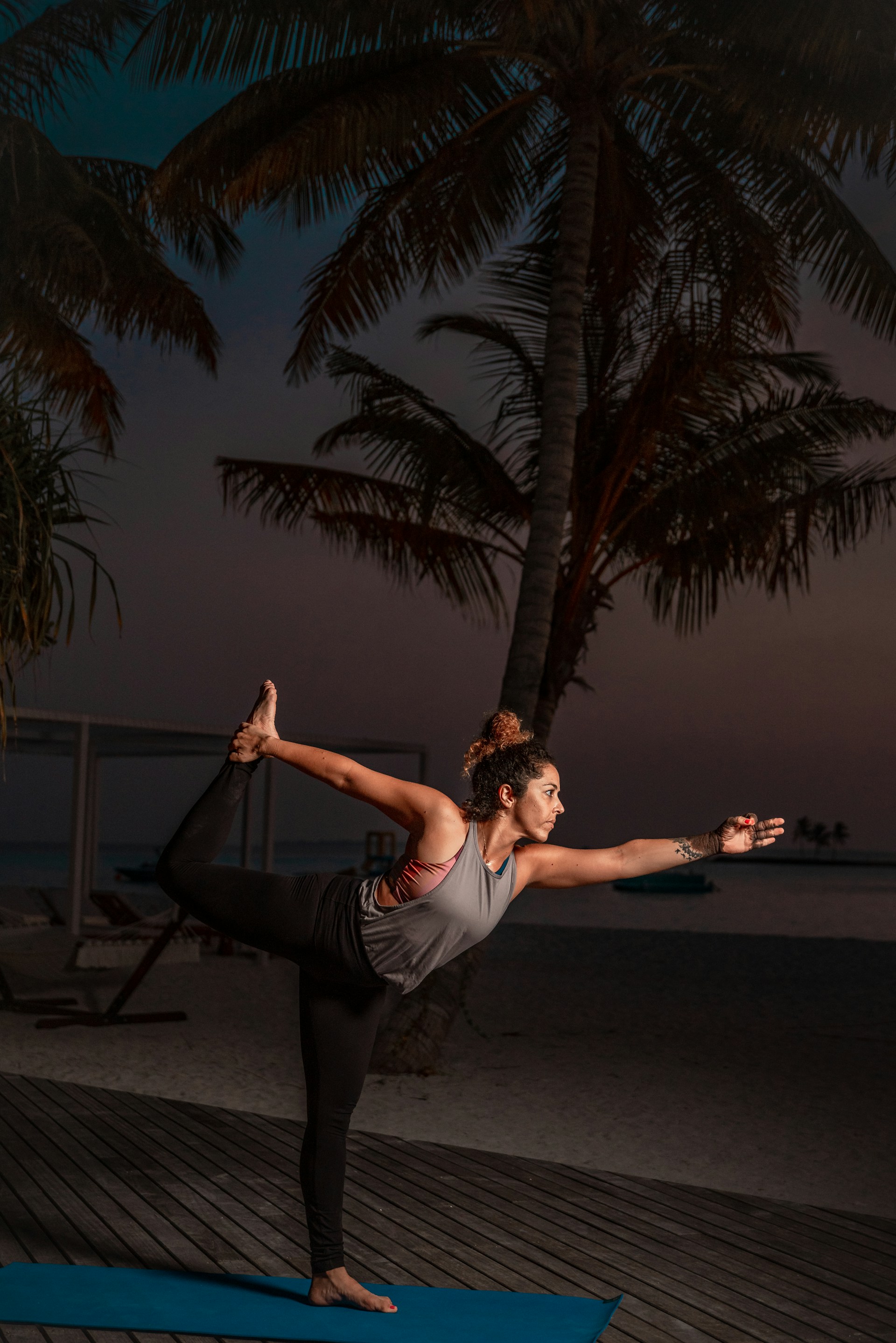 a woman doing a yoga pose on a blue mat