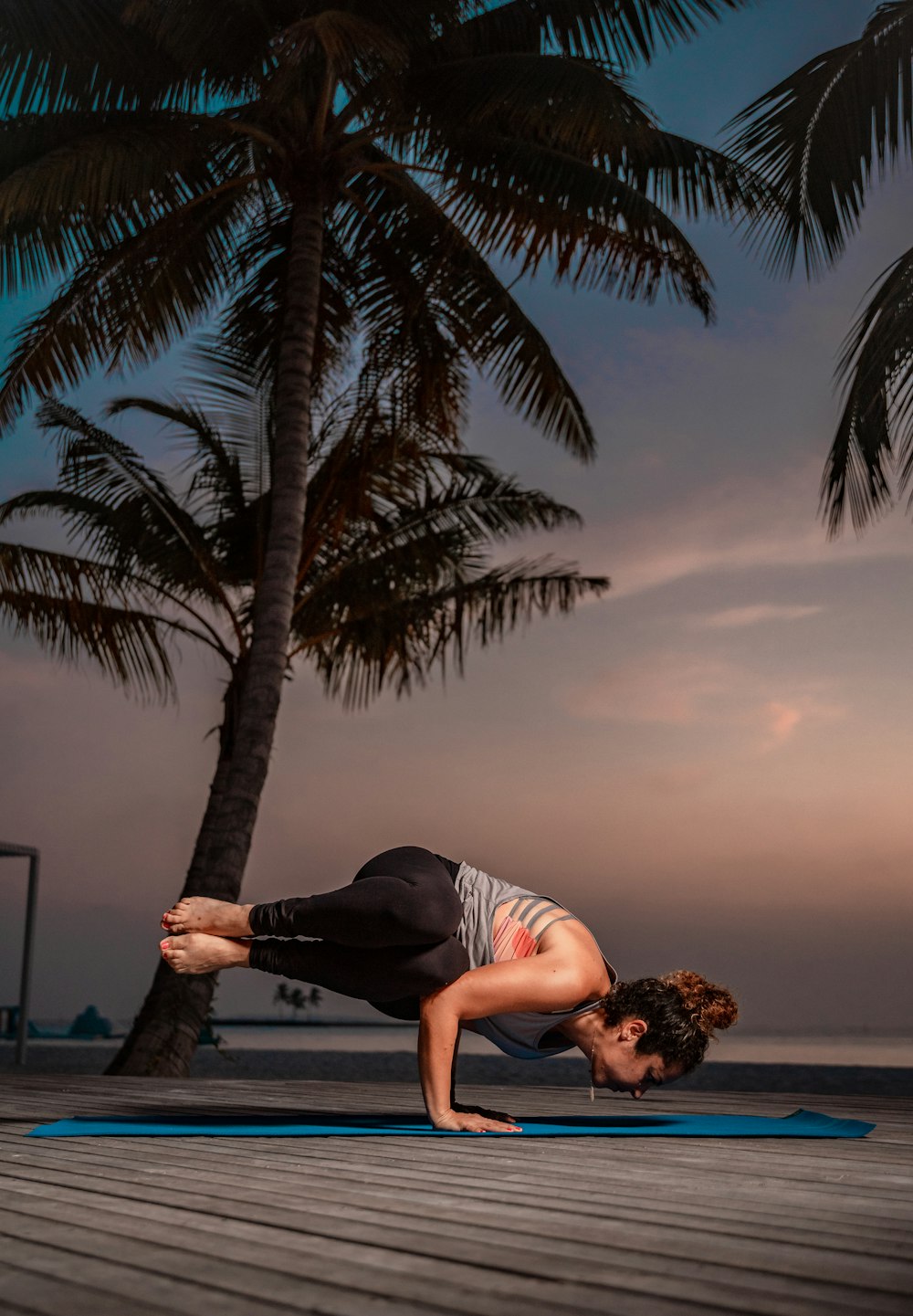 Una donna che fa una posa yoga su una stuoia blu