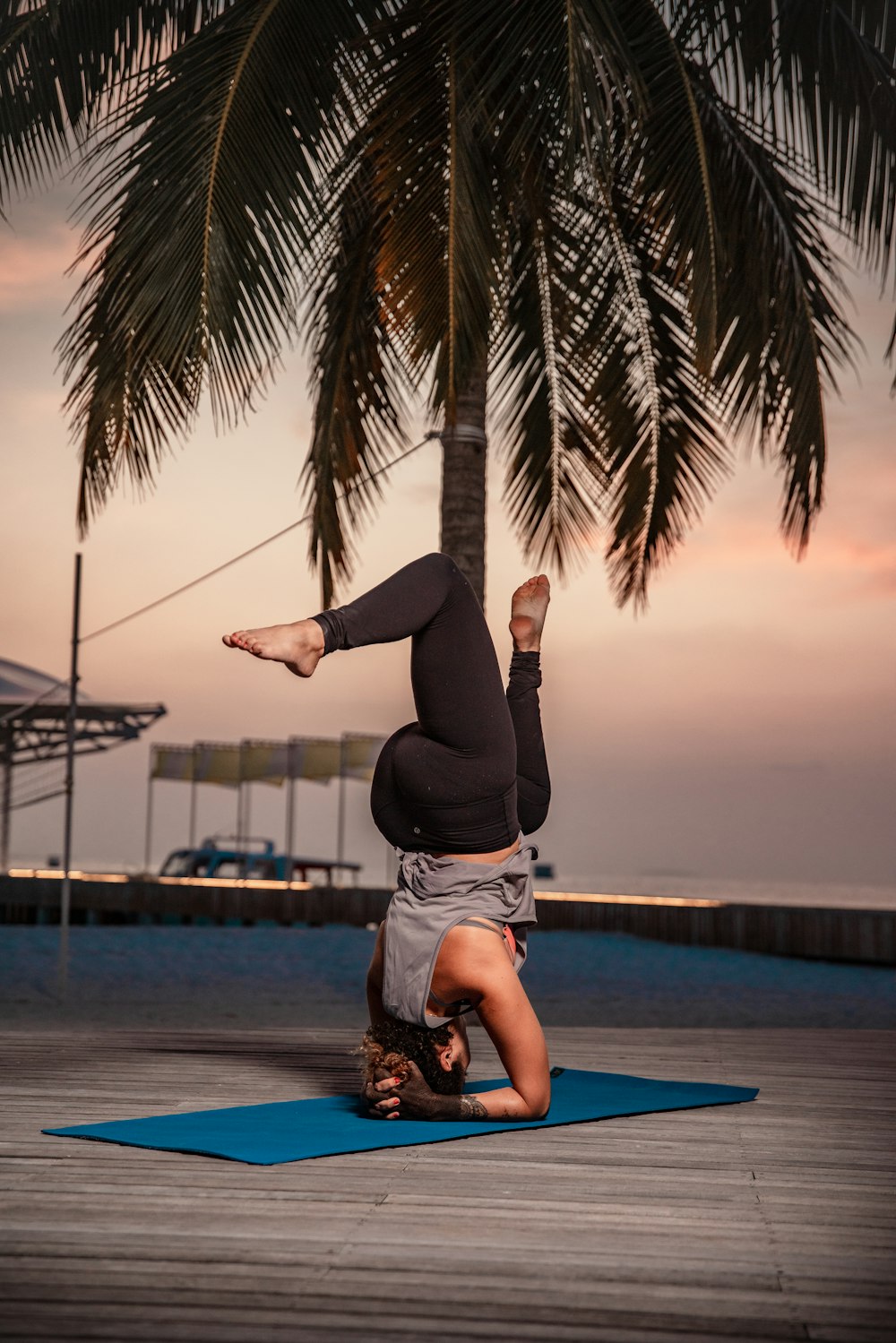 a woman doing a handstand on a blue mat