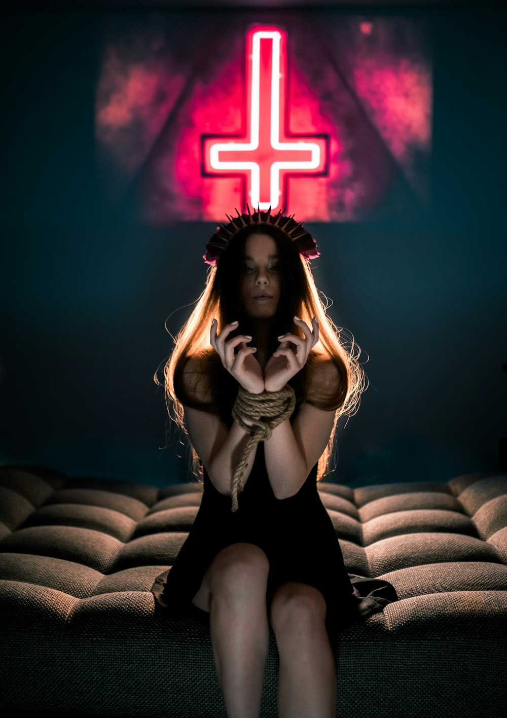 a woman sitting on a couch in front of a cross