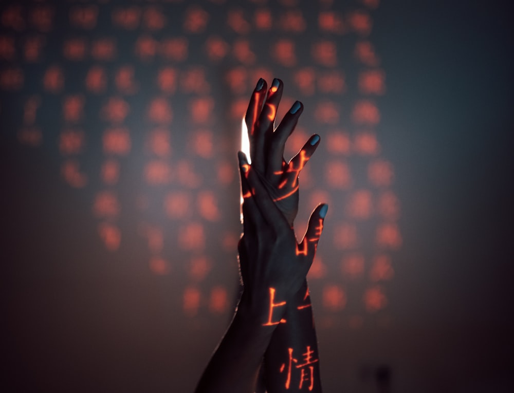 a person holding their hands up in front of a computer screen