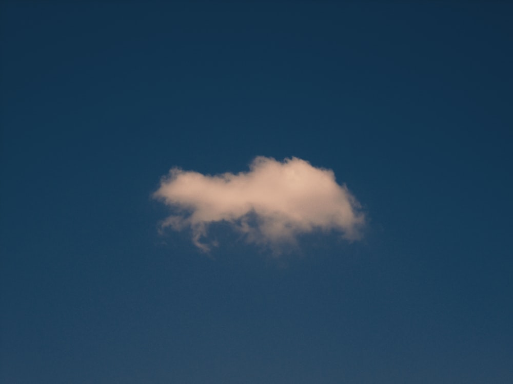 a white cloud floating in a blue sky