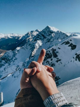 Close-up of a couple holding hands with mountains in the background