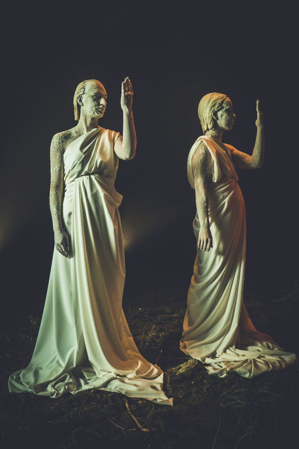 woman in white dress standing beside man in white robe