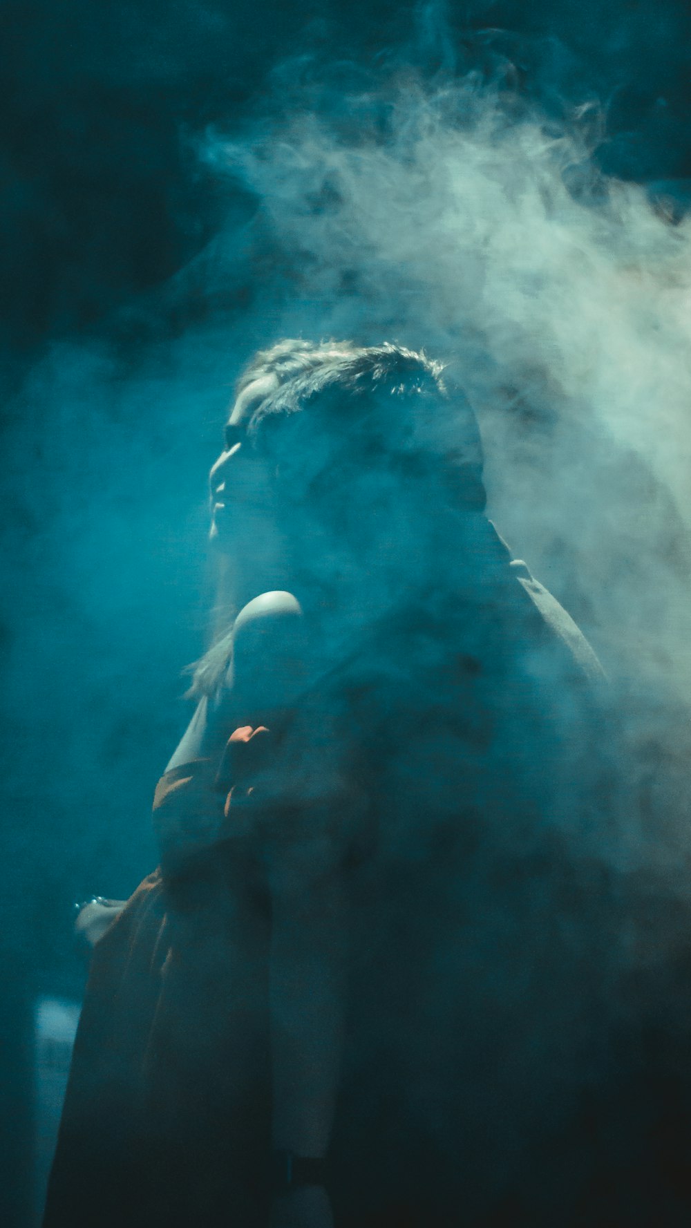 a person standing in front of a cloud of smoke