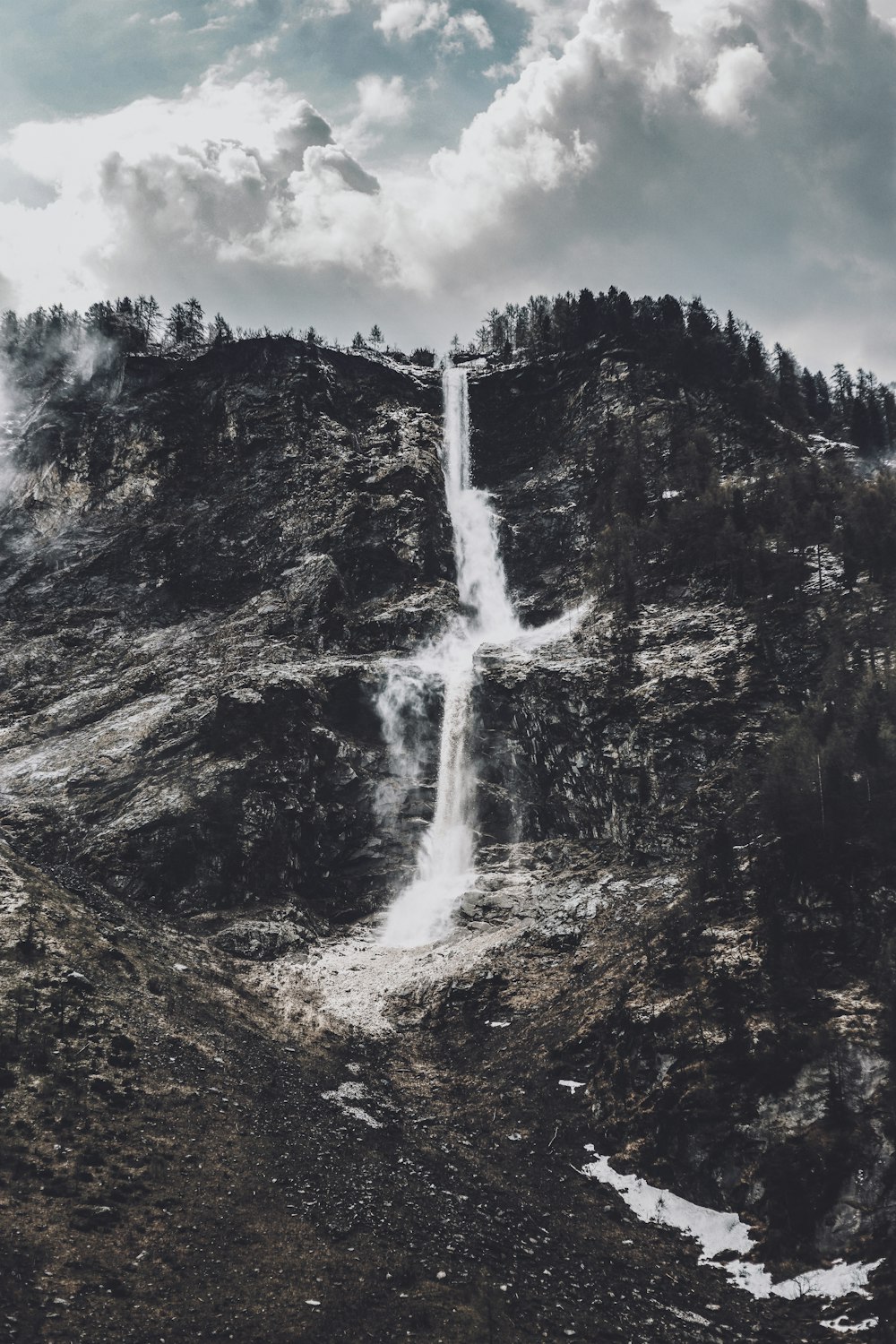 a very tall waterfall in the middle of a mountain