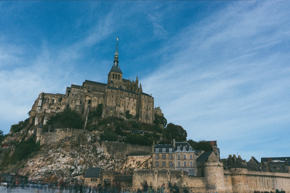 Un château au sommet d’une colline avec un fond de ciel