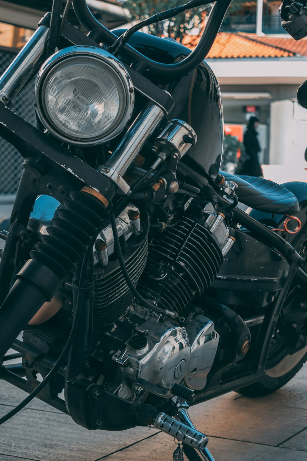 black and silver motorcycle in front of man in blue shirt