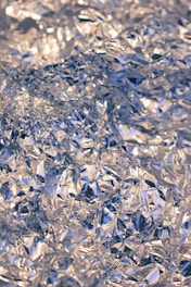 Crumpled silver foil creating a textured, reflective surface with intricate folds and creases.