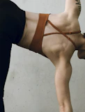 a woman in a brown bikini doing a handstand