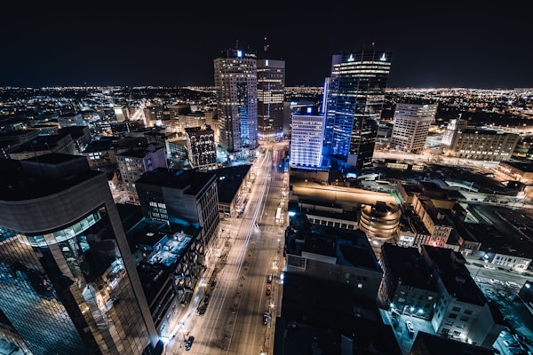 aerial view of city buildings during night timeby Josh Lavallee