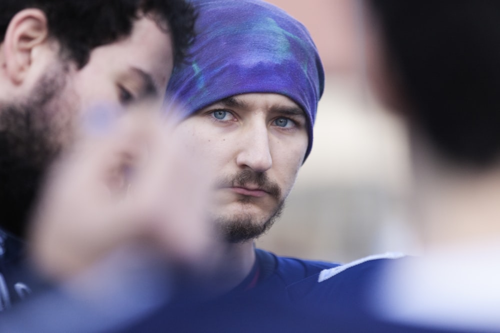 Un homme avec un turban bleu parle à un autre homme