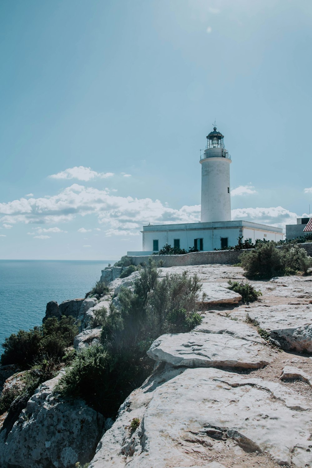 white lighthouse near body of water during daytime