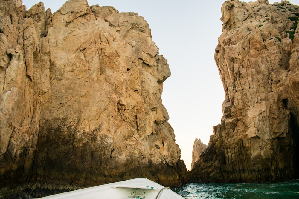 brown rock formation on body of water during daytime