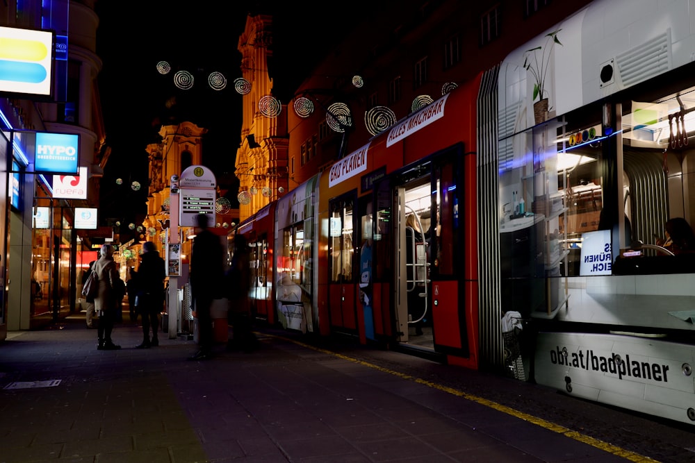 people walking on sidewalk during night time