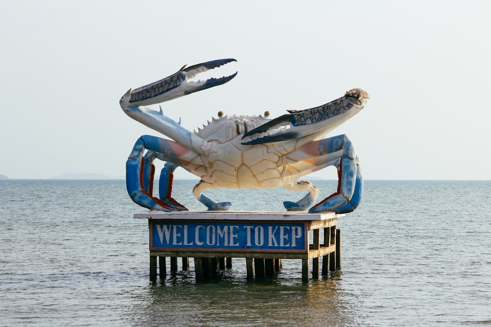 a large crab statue sitting on top of a wooden pier