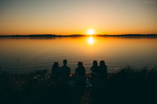 A serene outdoor setting with members discussing scripture under a golden sunset.
