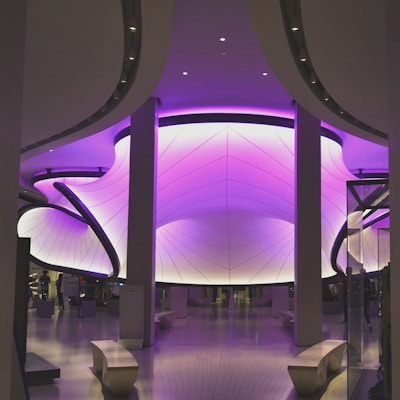 A sleek, futuristic office space bathed in violet and black lighting, reflecting innovation.