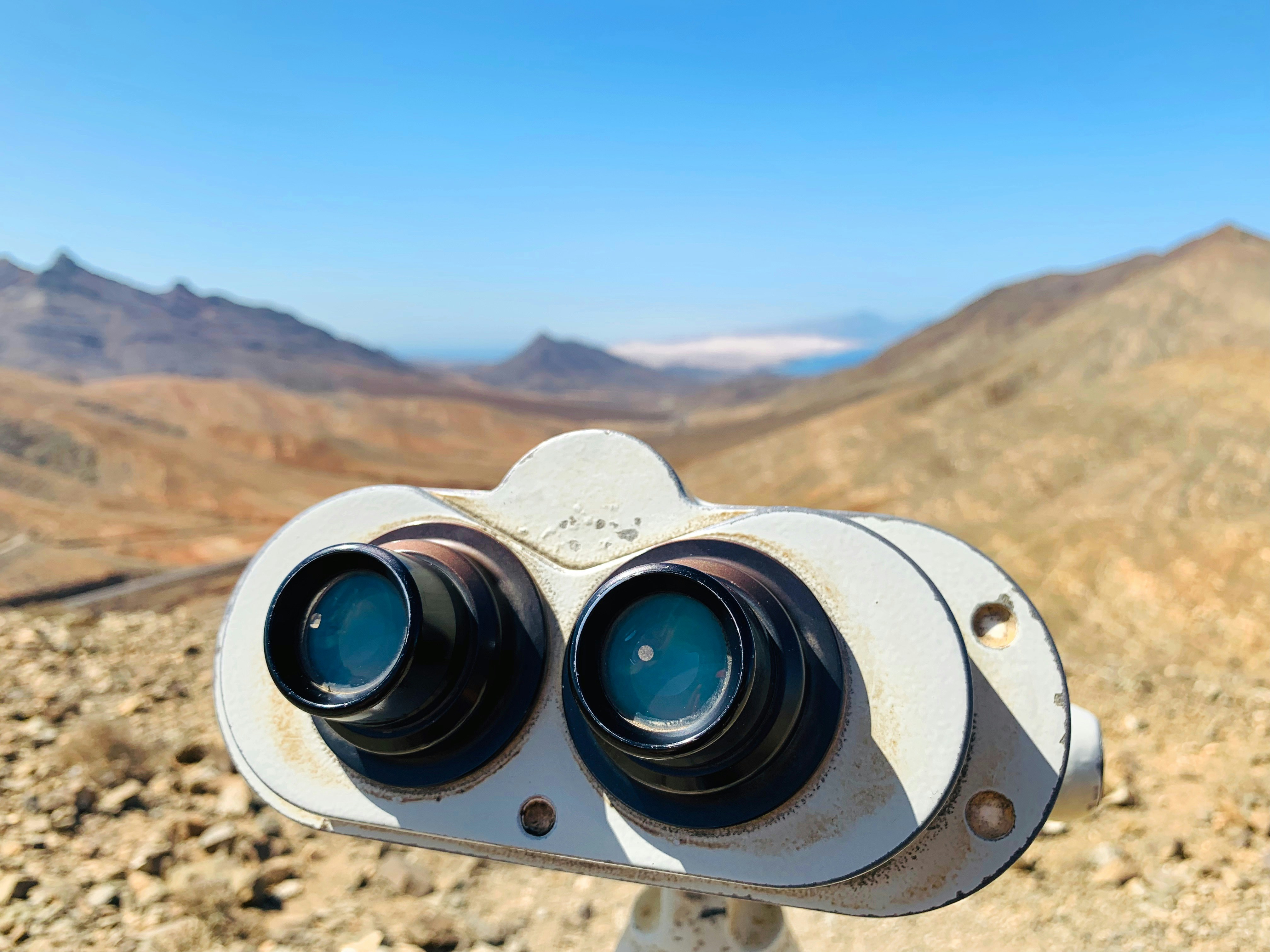 White binoculars on brown rock formation during daytime photo Free