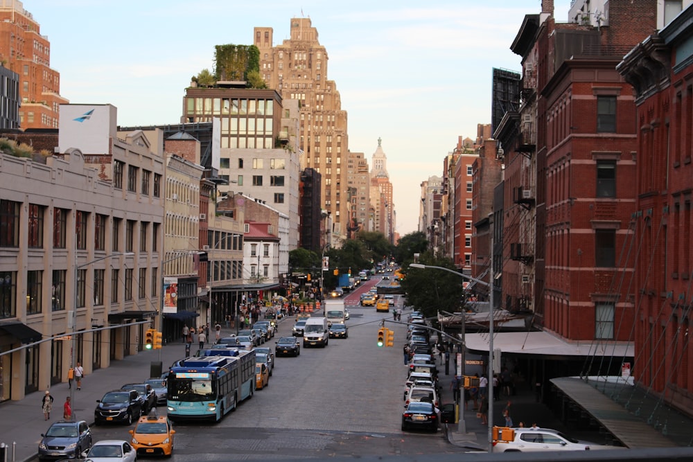 cars on road between high rise buildings during daytime