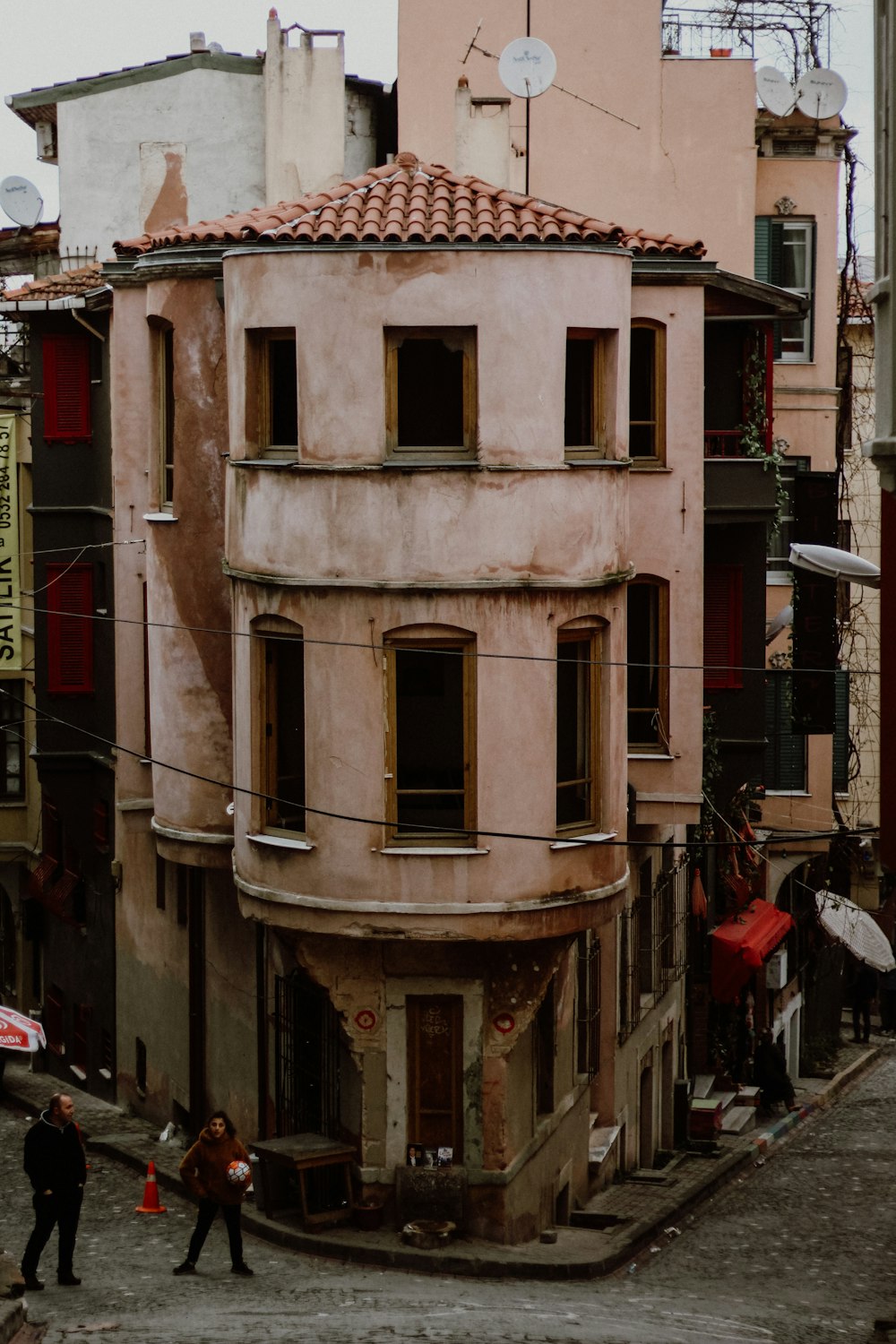 an old building with a red umbrella on a city street