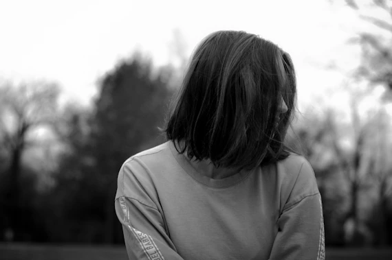 a person standing in a field with trees in the background