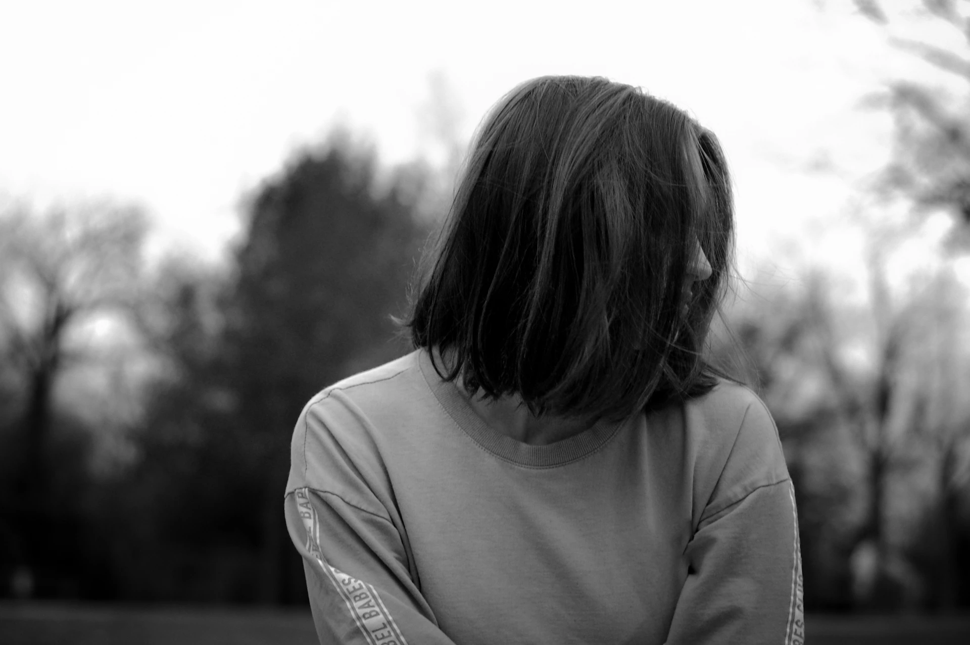 a person standing in a field with trees in the background