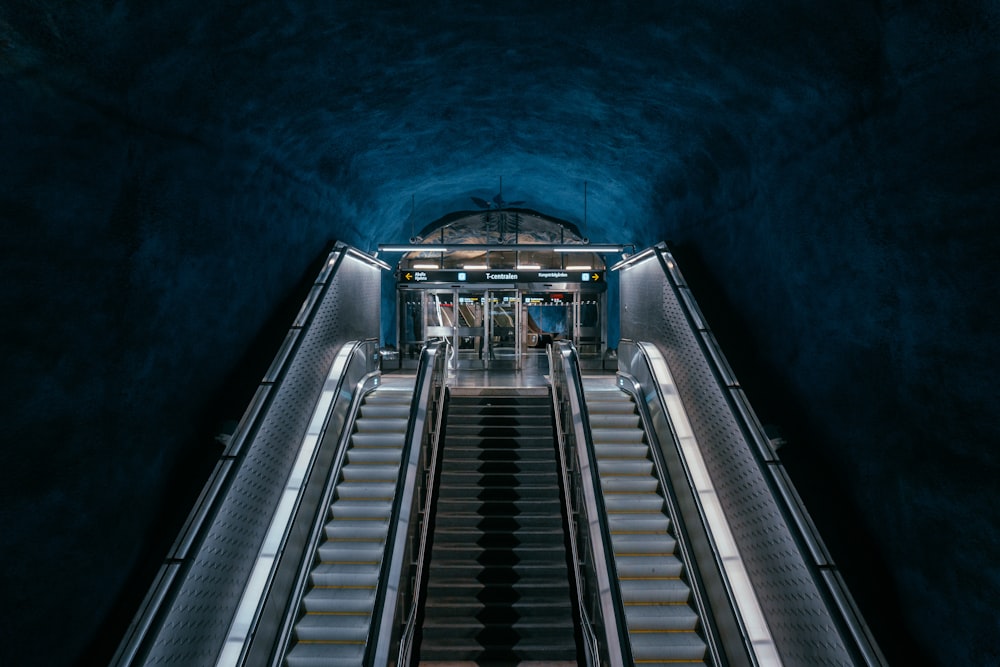 an escalator in a tunnel with stairs leading up to it