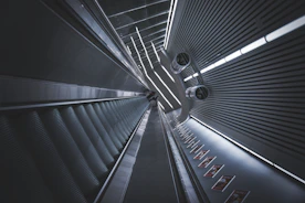 Technicians installing an escalator in a busy commercial building.