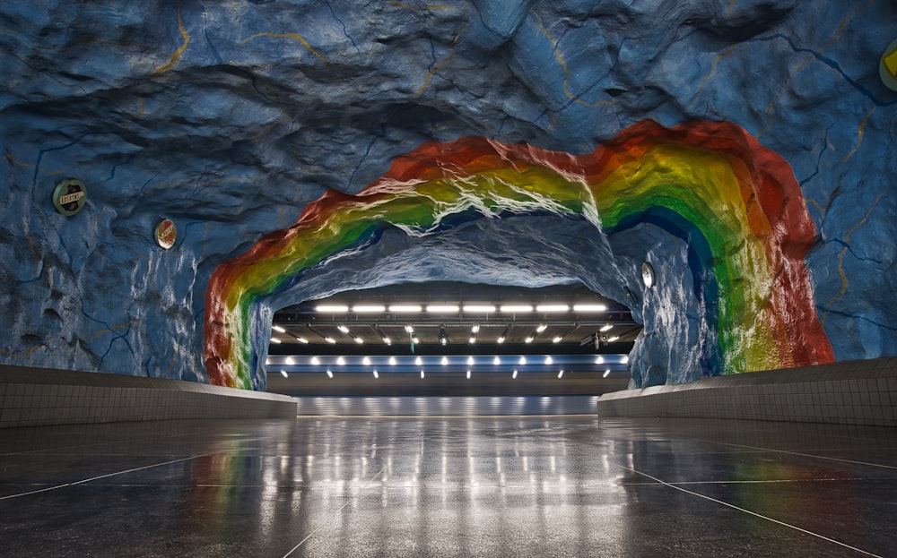 Un tunnel très coloré avec un arc-en-ciel peint sur le mur