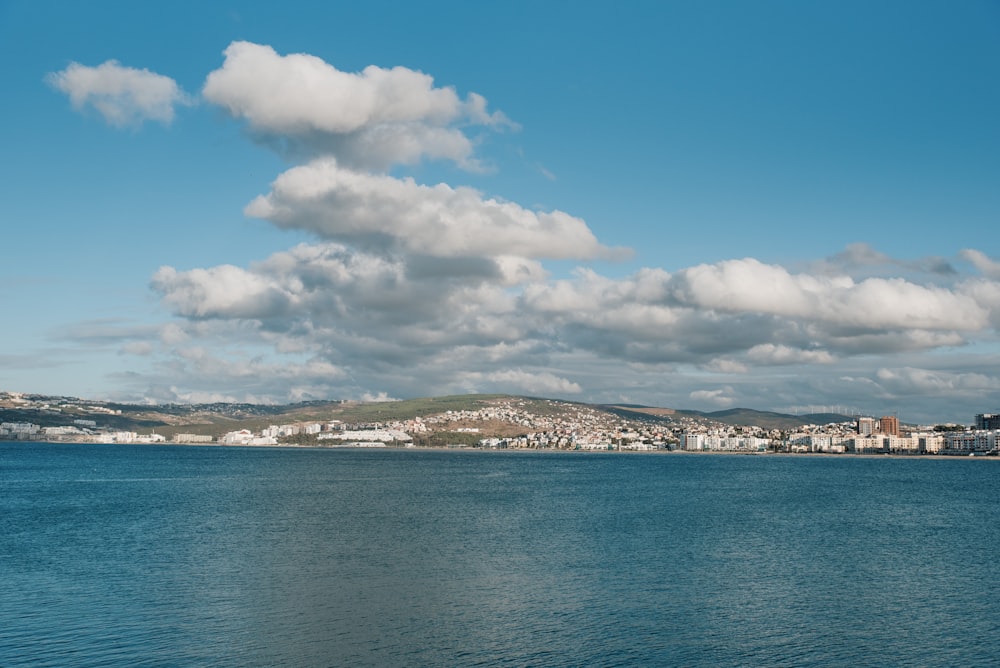 white clouds over the city by the sea during daytime
