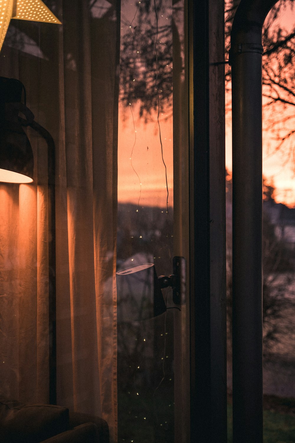 brown curtain on glass window during sunset