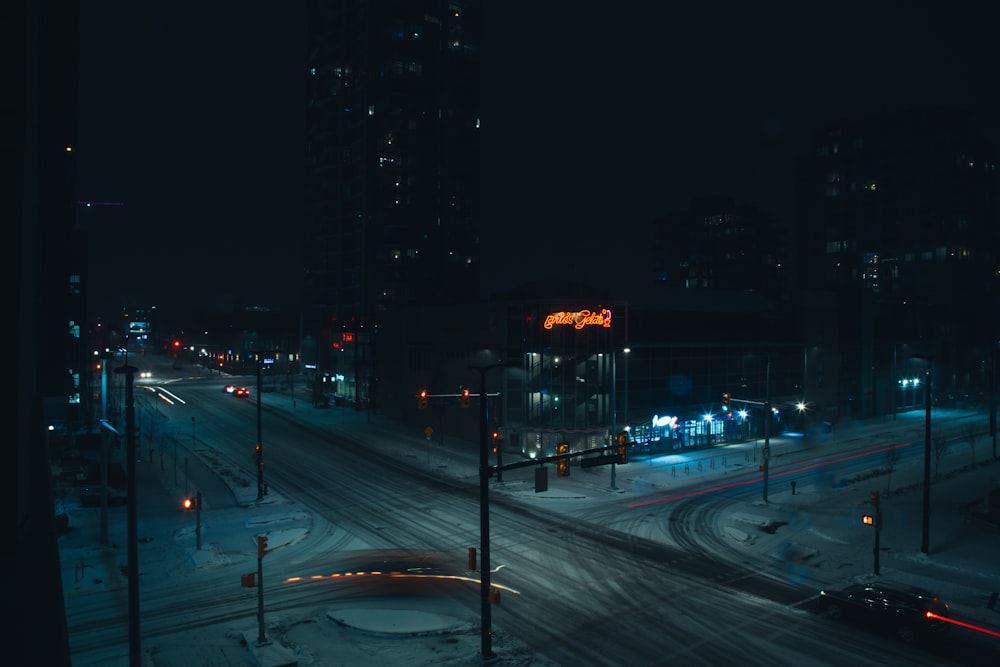 a city street at night covered in snow