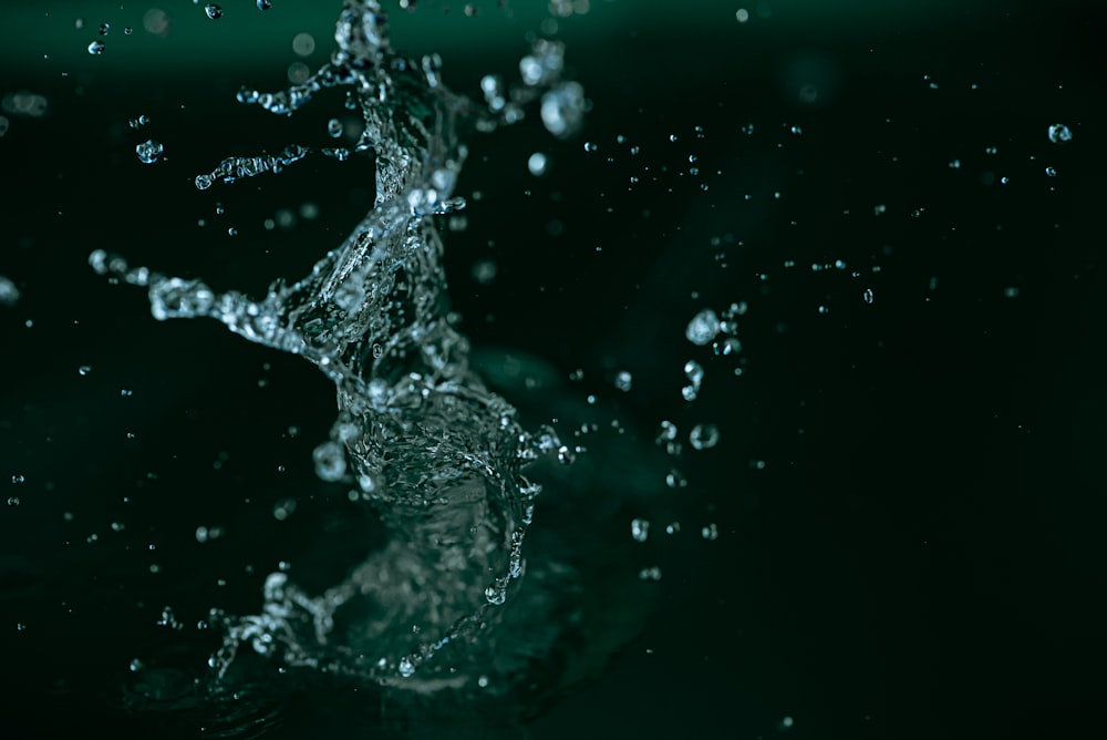 water splashing on a black surface with a green background