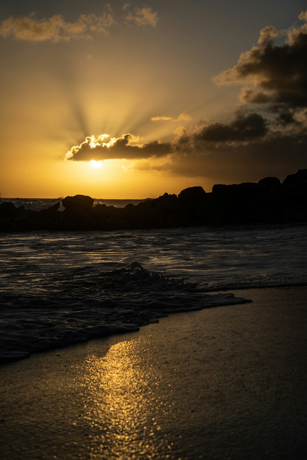 the sun is setting over the ocean on the beach