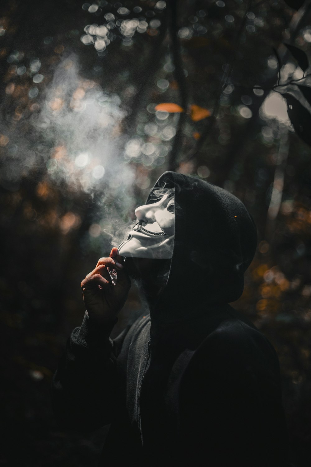 uma pessoa com uma jaqueta com capuz fumando um cigarro