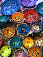 A set of decorative bowls in bold colors displayed on a rustic table.